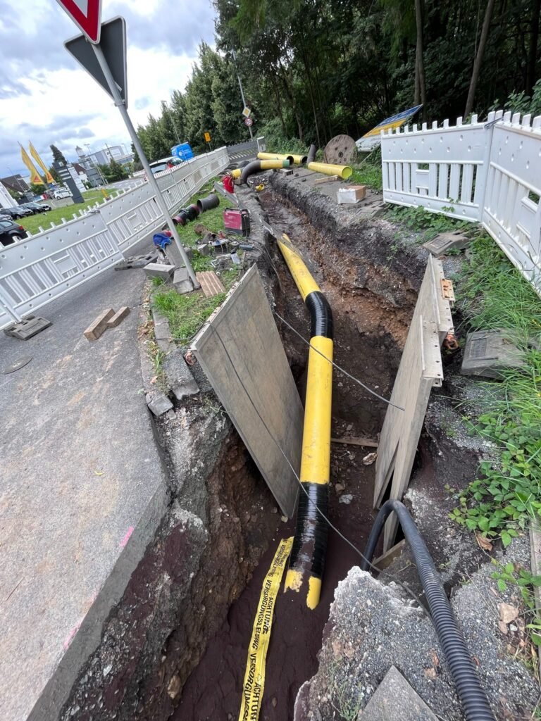 Gelbe Gasleitung in einem verbauten Graben an einer Straße