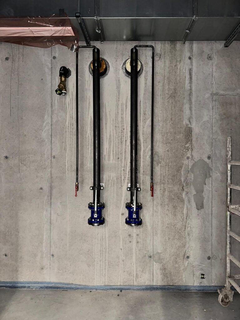 Rohranschlüsse an einer Betonwand montiert