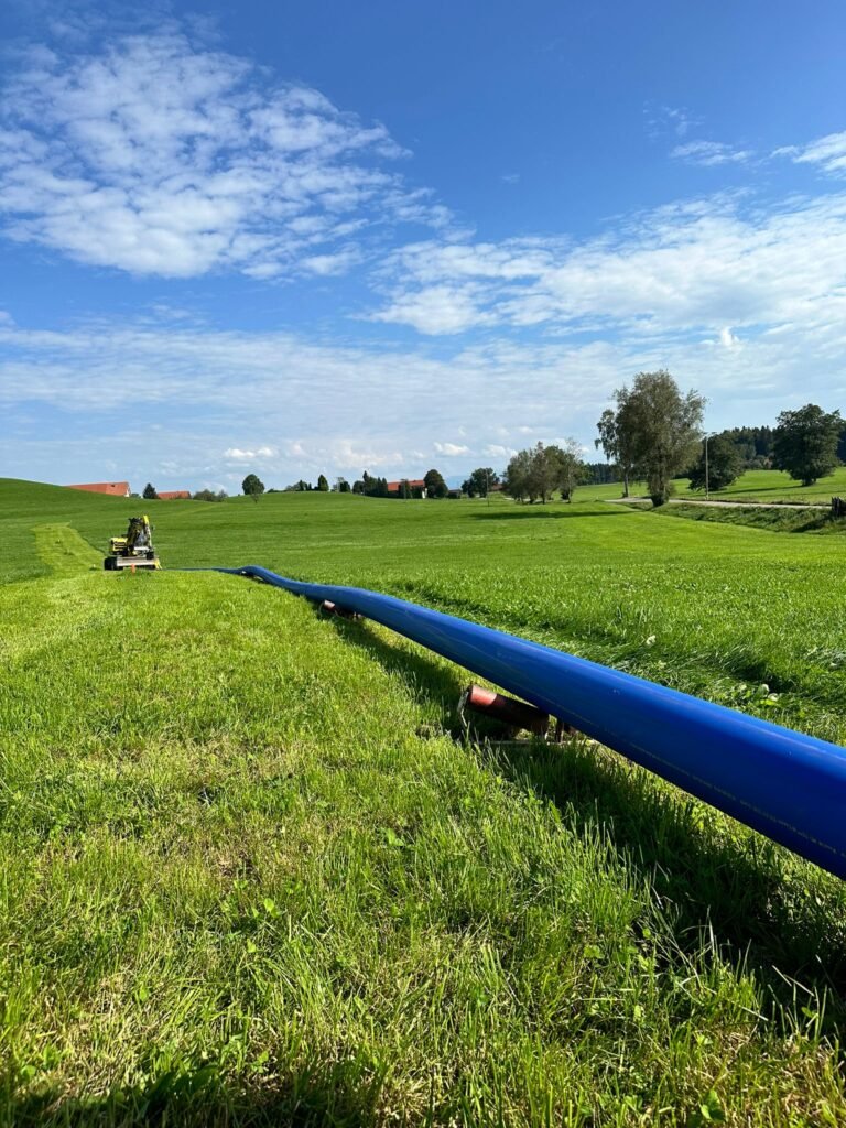 Blaue PE-Leitung über eine Wiese verlegt