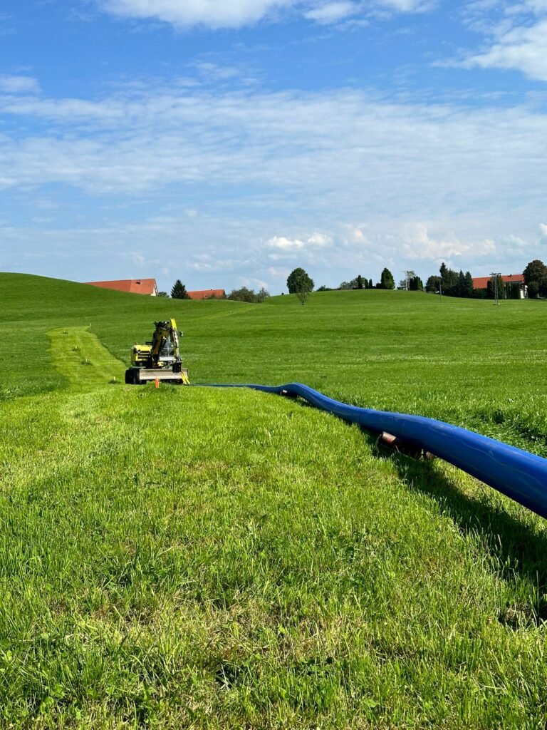 Blaue PE-Leitung über eine Wiese verlegt