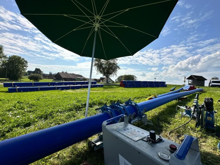 PE-Stumpfschweißmaschine an einer blauen PE-Leitung auf einem Feld