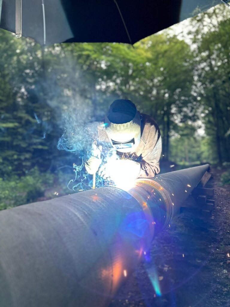 Nahaufnahme: Lichtbogenschweißen an einer Stahlrohrleitung
