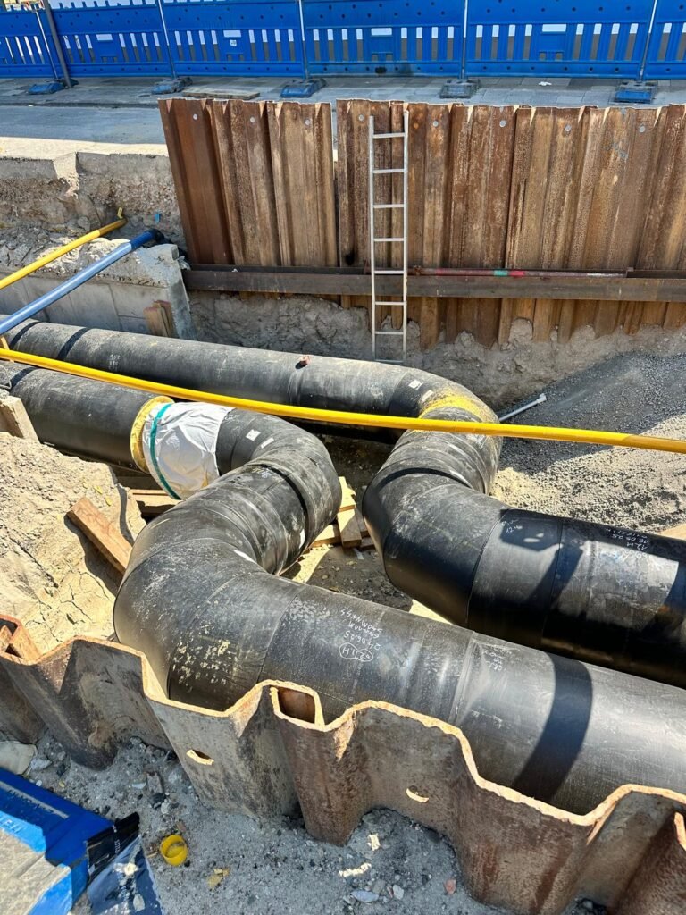 Rohrbögen und Verbindungen in einer verbauten Baugrube