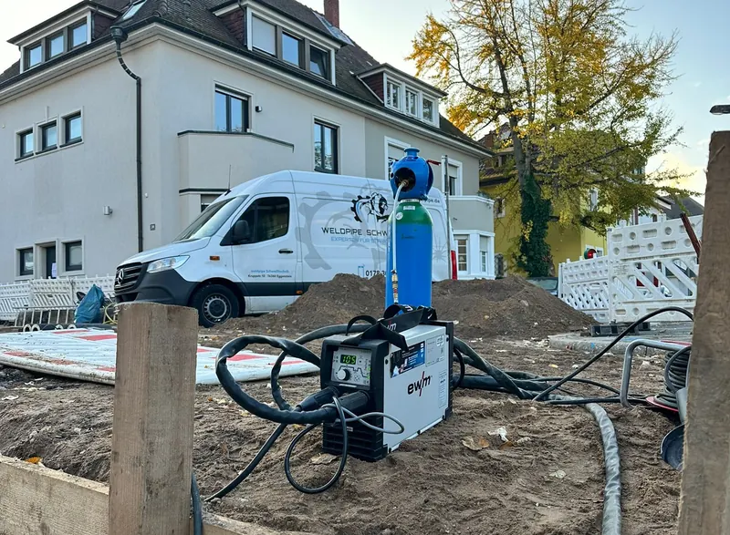 Schweißgerät und Gasflasche neben einem Graben